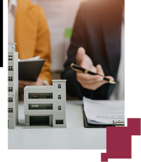 Miniatura de un edificio y personas detrás firmando documentos